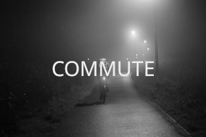 The back of a cyclists on a small tarmacked cycle path at night. Street lights and the bicycle lights illuminate the foggy scene. Over the image the word 'Commute' is written in uppercase white letters.
